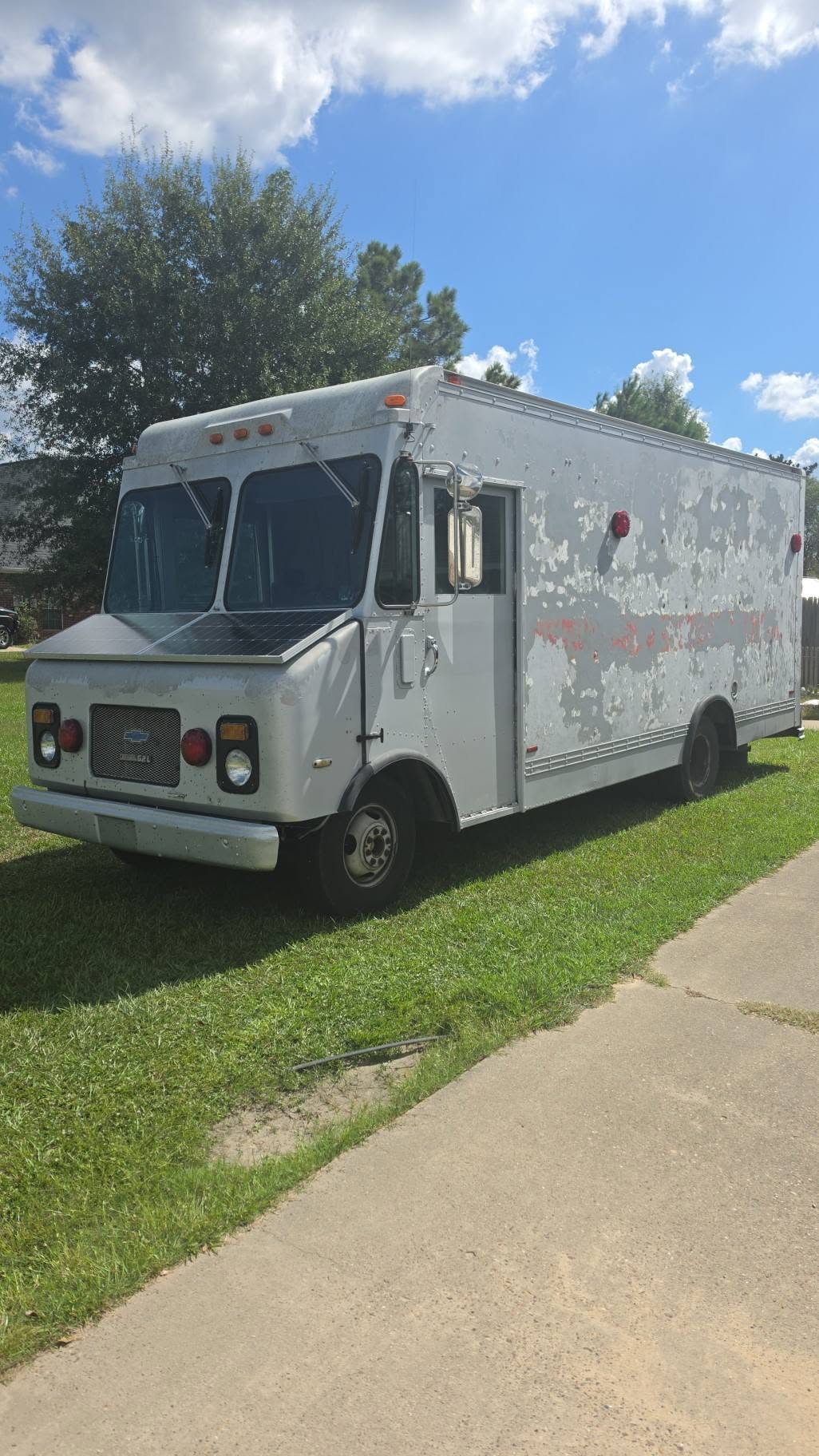 The white 1988 Chevrolet P30 mobile service unit in daylight